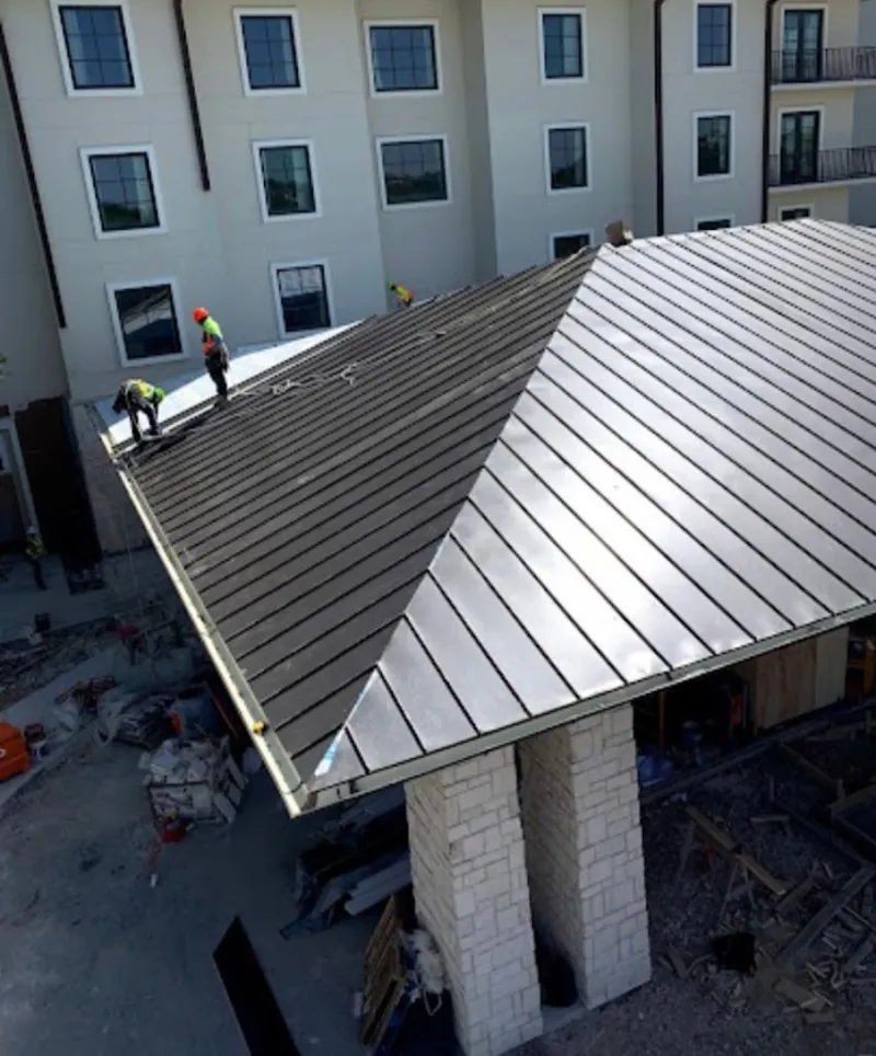 Crew installing standing seam metal roof panels on a commercial project in Cleveland
